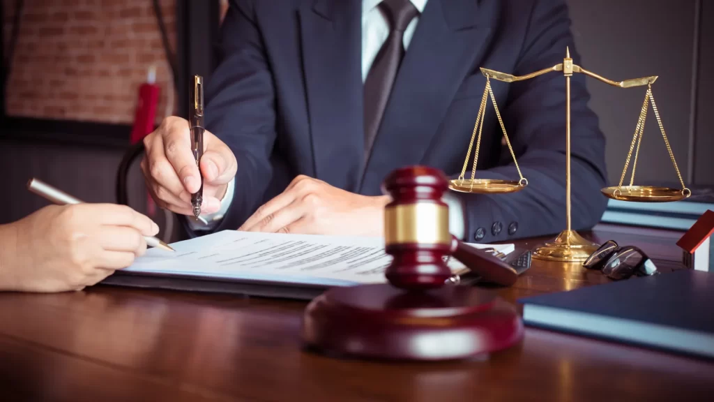 a personal injury lawyer holding a pen and gavel on the table